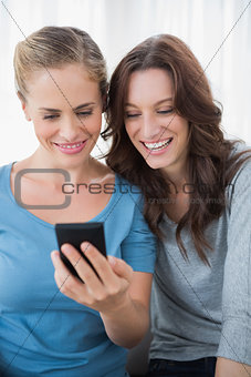 Smiling friends reading message on their phone