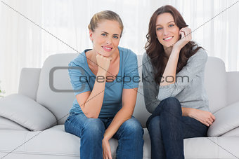 Pretty women posing while sitting on the couch