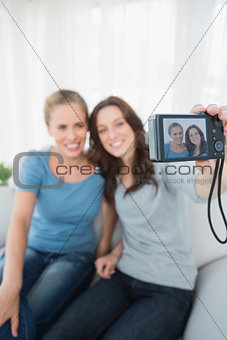 Cheerful friends taking pictures of themselves