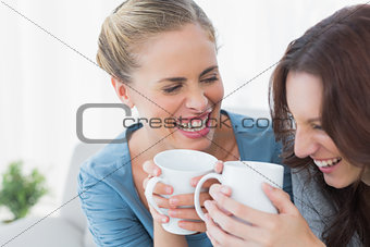 Friends bursting out laughing while having coffee