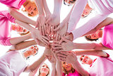 Diverse women smiling in circle wearing pink for breast cancer