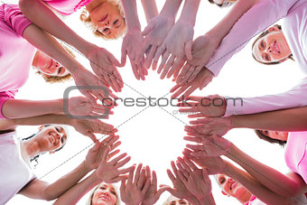 Happy women in circle wearing pink for breast cancer