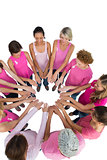 Happy women joined in a circle and looking at each otherwearing pink for breast cancer