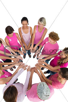 Happy women joined in a circle and looking at each otherwearing pink for breast cancer
