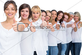 Cheerful casual models posing in a line thumbs up