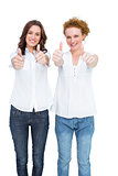 Two gorgeous casual models posing with thumbs up