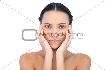 Young attractive model with hands on face looking at camera