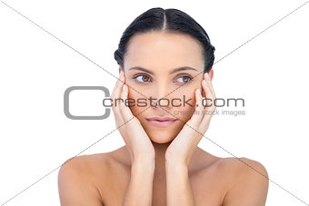 Young attractive model with hands on face looking away
