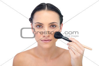 Natural model applying makeup on her face