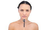 Frowning young model holding eyebrow brush