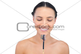 Relaxed young model holding eyebrow brush