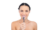 Relaxed young model holding eyebrow brush in front of her