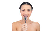 Enthusiastic young model holding eyebrow brush in front of her