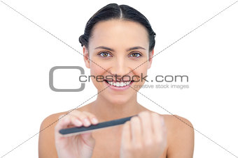 Smiling natural young model using nail file