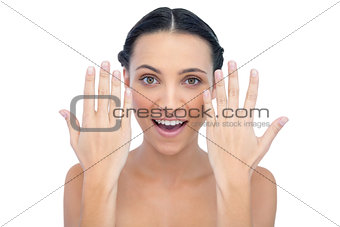 Surprised natural model posing with hands up