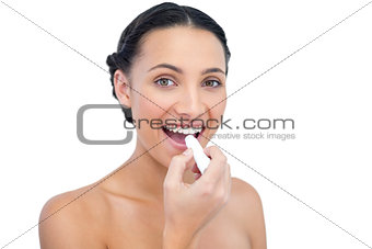 Enthusiastic young natural model applying lip balm