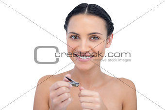 Cheerful natural model using nail clippers