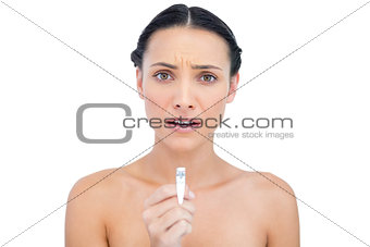 Anxious young brunette holding nail clippers