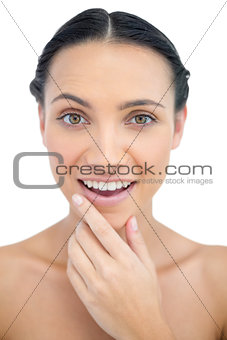 Smiling sensual model posing while touching her chin