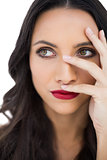 Thoughtful dark haired woman with red lips hiding her face