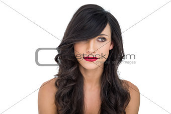 Pensive dark haired woman posing with red lips