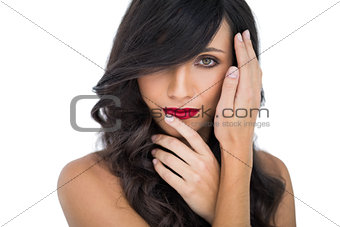 Glamorous brunette posing finger on her red lips