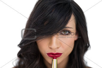 Sensual brunette applying red lipstick