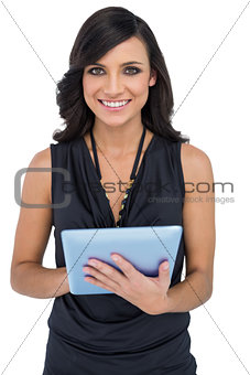 Smiling elegant brown haired model using tablet-computer