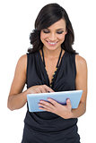 Smiling elegant brown haired model scrolling on tablet