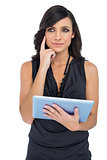 Thoughtful elegant brown haired model holding tablet