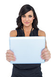 Peaceful elegant brown haired model holding tablet in front of her