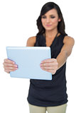 Elegant dark haired model looking at her tablet pc