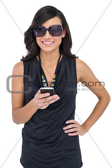 Cheerful elegant brunette wearing sunglasses sending message