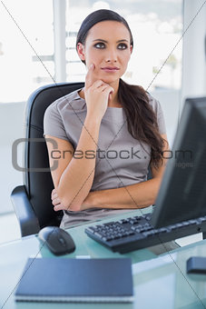 Pensive businesswoman sitting on her swivel chair
