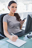 Sexy businesswoman using calculator and writing