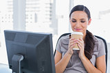 Happy attractive businesswoman holding coffee