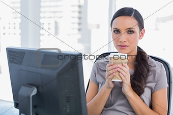Serious attractive businesswoman holding coffee