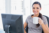 Smiling attractive businesswoman holding mug