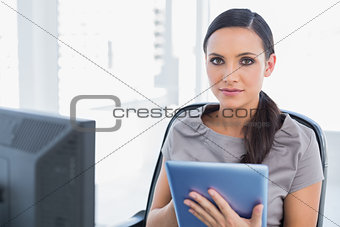 Calm attractive secretary using tablet pc