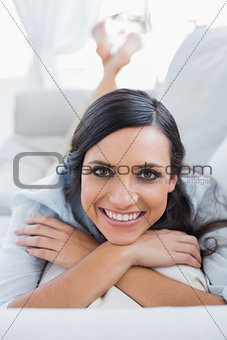 Cheerful dark hair woman lying on the couch