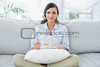 Pretty woman sitting on the couch crossing legs