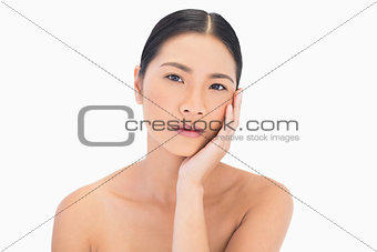 Natural model posing touching her cheek