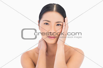 Natural dark haired model posing touching her face