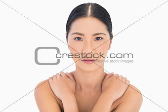 Natural dark haired model posing hands on shoulders