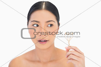Worried natural model with eyelash curler