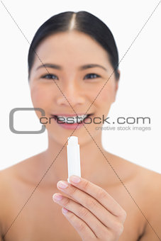 Cheerful gorgeous natural model holding chap stick
