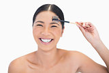 Laughing gorgeous natural model using eyebrow brush