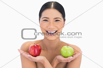 Smiling natural brunette holding apples in both hands