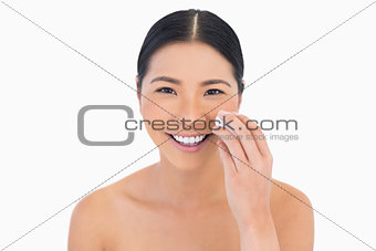Cheerful beautiful model removing her make up
