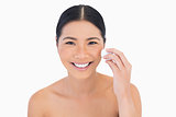 Smiling beautiful model using cotton pad on her face